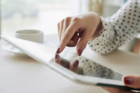 Photo tablette et main naviguant sur le web 